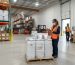Nutraceutical ingredient supplier USA warehouse with labeled pallets and worker in PPE.